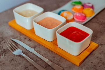 Sorrentinos en plato con salsa de colores y servilletas