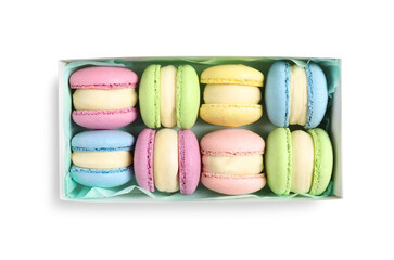 Many delicious colorful macarons in box on white background, top view