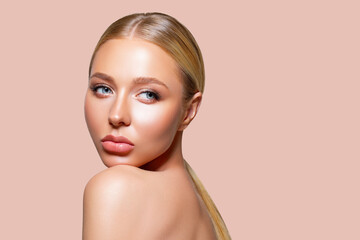 Beauty woman clean healthy skin natural make up. Peach background. Beauty. Fashion Beauty Portrait model looks over the shoulder. Isolated. Makeup. long smooth hair blonde. Plump lips    - obrazy, fototapety, plakaty
