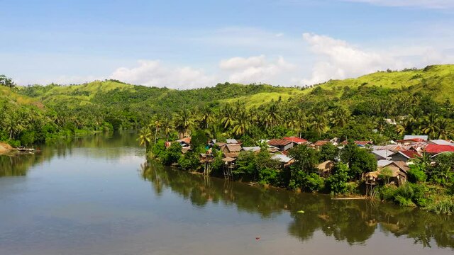 Tropical landscape in sunny weather. Village by the river. Green hills and river. Summer and travel vacation concept. The nature of the Philippine Islands, Samar