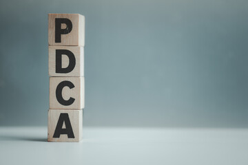 PDCA written in wooden cubes, plan do check act concept