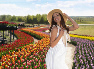 Woman in beautiful tulip field on sunny day