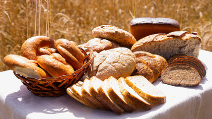 lot of different flavored bread, wheat, rye, on the table in the field outside