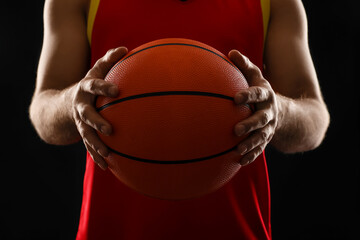 Basketball player with ball on black background, closeup