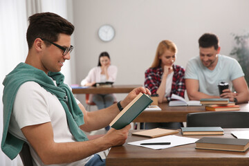 Man reading book at table in library
