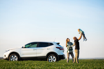 Young family with kids travelling by car, stopped in the field