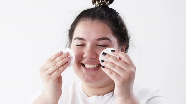 Facial Cleansing. Skin Treatment. Morning Routine Hygiene. Body Positive. Confident Cheerful Smiling Overweight Obese Woman Cleaning Face With Tonic Cotton Pad Isolated On White.