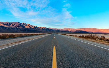 The road crossing the desert and going to the mountains.