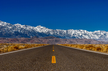 The road running adjacent to the mountains.