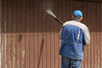 Hose the wall. Washing from the dirt of the fence.
