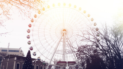 Ferris wheel on cloudy sky background vintage color.
