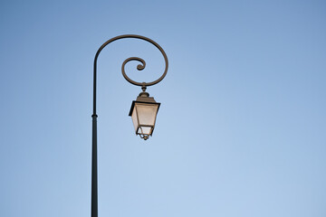 old lamppost on the background of blue sky