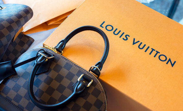 July 26, 2021: Nakhon Prathom, THAILAND, On the table is a Louis Vuitton bag, as well as another generic handbag brand. Louis Vuitton is a luxury fashion house that specializes in leather items.
