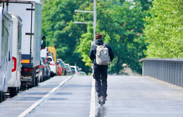  man with a backpack rides an electric scooter on a bicycle path