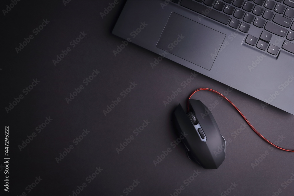 Fototapete above photo of laptop keyboard and computer game mouse isolated on the black background with empty s
