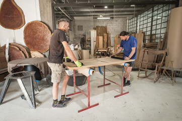 Two carpenters making furniture in a workshop. Woodworking and crafts tools