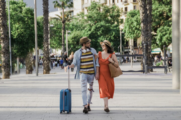 Happy hipster couple of tourist walking by the city at vacation holiday - Tourism and traveler people concept - obrazy, fototapety, plakaty