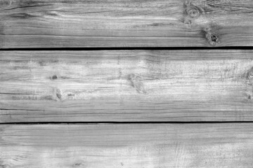 Wall made of uncutted weathered wood boards in black and white.