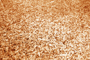 Granite surface as background with blur effect in orange tone.