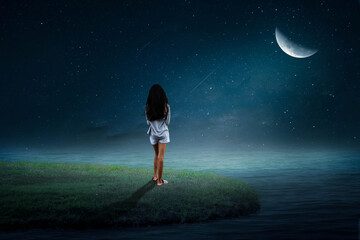 A little girl stood alone on the island in the middle of the sea on the half moon night.