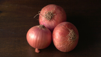 Fresh red onions in a wooden bowl.