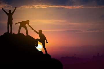 Teamwork friendship hiking help each other trust assistance silhouette in mountains, sunrise....