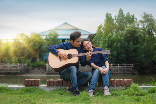 Asian Couple playing guitar rest in summer