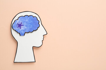 Top view of human head cutout with brain on beige background, space for text. Epilepsy awareness