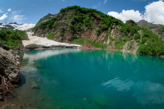 mountain lake Turie with the remains of an snow avalanche in Dombai