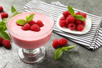 Delicious raspberry mousse with mint on grey table, space for text