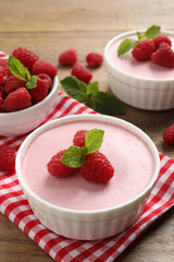 Delicious raspberry mousse with mint on wooden table