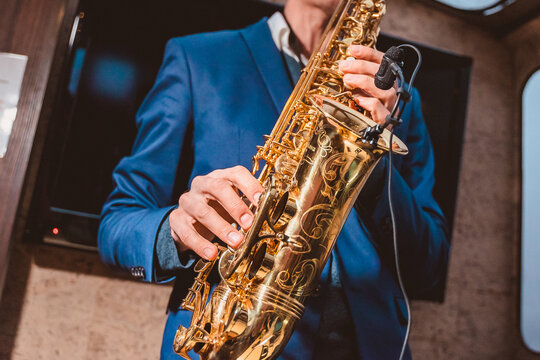 a man plays a saxophone with a microphone attached in front