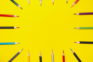 Wooden colored pencils placed on a yellow background. Education and back to school concept.