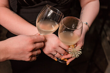 a glass clinks with a glass of fruit cider in the hands of a girl