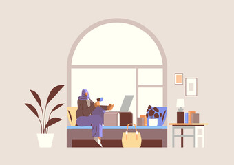arab woman with credit card using laptop online shopping concept living room interior horizontal