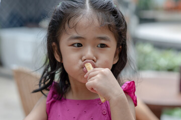 Fototapeta na wymiar Asian children girl having fun to eating snacks.
