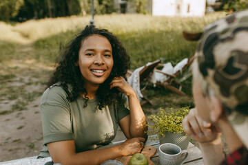 Beautiful african american girl relax on nature having lunch with boyfriend. Couple having picnic on fresh air on countryside. Holiday, travelling, peace, freedom, nature concept