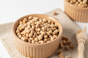 dry chickpeas, in a ceramic dish on a white table, close-up