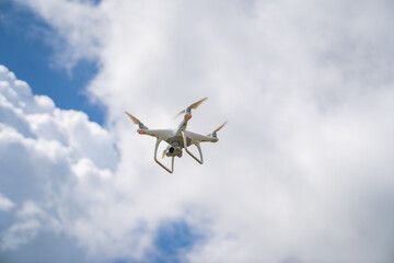 a white drone flies in the blue sky and shoots a video. 