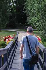 man walking across wooden bridge