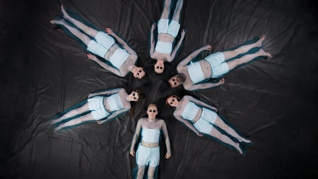 Rotating video of lying men and women with duct tape on eyes