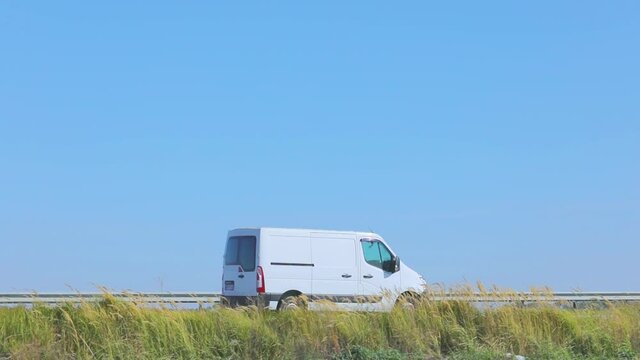 A small truck is driving along the highway. The car is driving along the highway