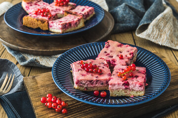 Pieces of creamy red currant pie on a blue plate on wooden background