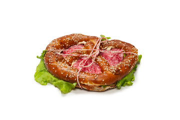 Pretzel with salami and lettuce isolated on a white background.