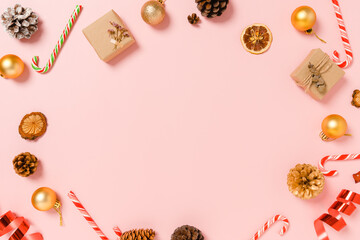 Minimal creative flat lay of christmas traditional composition and new year holiday season. Top view winter christmas decorations on pink background with blank space for text. Copy space photography.
