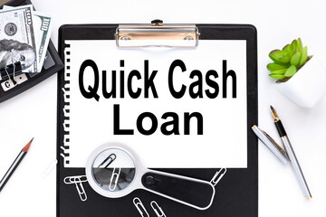 Quick Cash Loan, text on a white sheet of paper near a magnifying glass m flowerpot in a pot