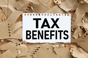 TAX BENEFITS, text on white paper on torn kraft paper background