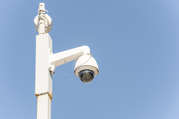 Video surveillance camera on a pole, close-up, on a blue background