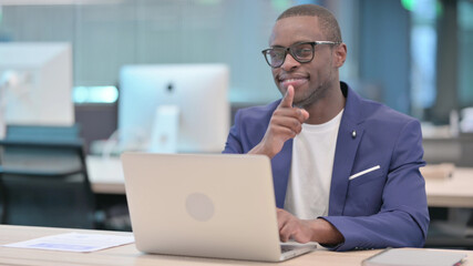 Young African Businessman with Laptop Pointing with Finger