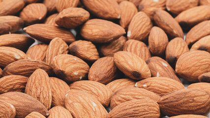 Background of almonds scattered, Almonds in wooden spoon, Background of almonds scattered.